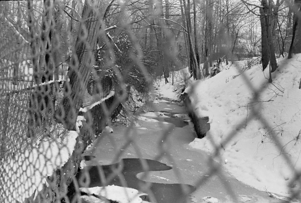 Fence at left rear of the amphitheater as it leaves school property