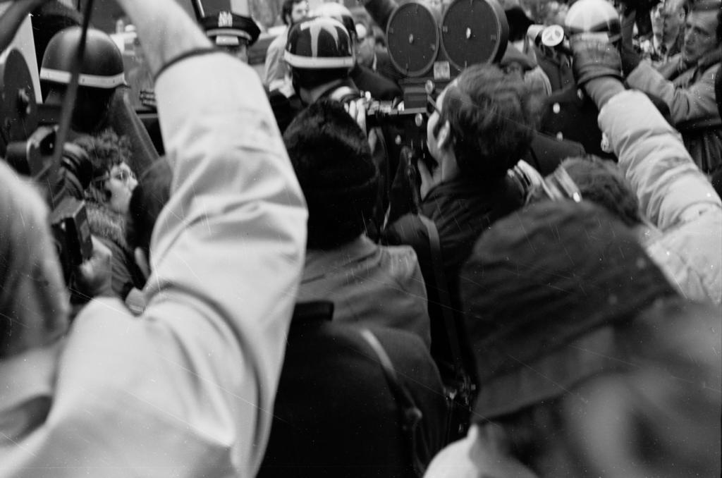 a crowd of news staff and demonstrators